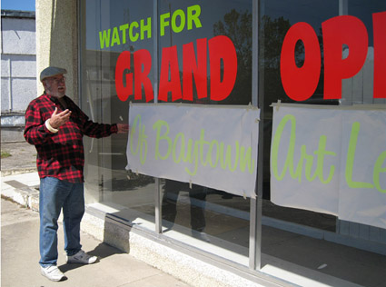 Ken the Dauber Pridgeon puts the finishing touches on the new Baytown Art League building's front window.